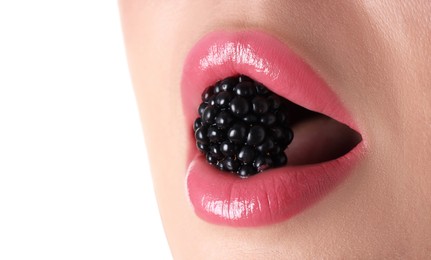Photo of Woman with beautiful pink lipstick on her lips and blackberry against white background, closeup