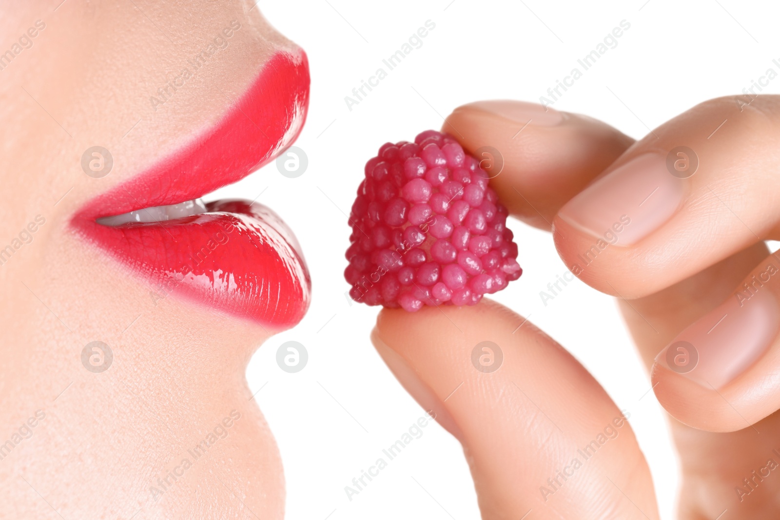 Photo of Woman with beautiful red lipstick on her lips and raspberry candy against white background, closeup