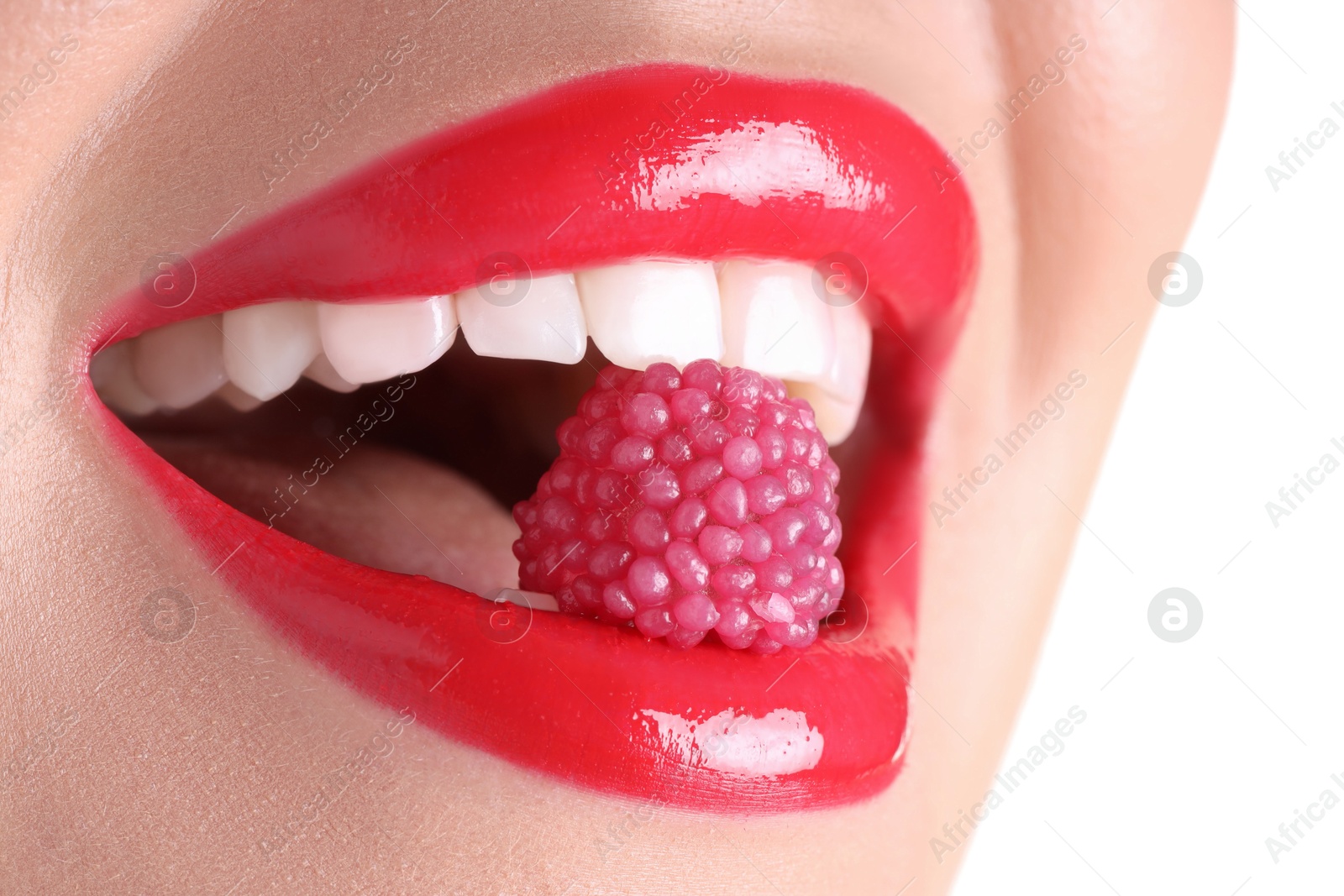 Photo of Woman with beautiful red lipstick on her lips and raspberry candy against white background, closeup