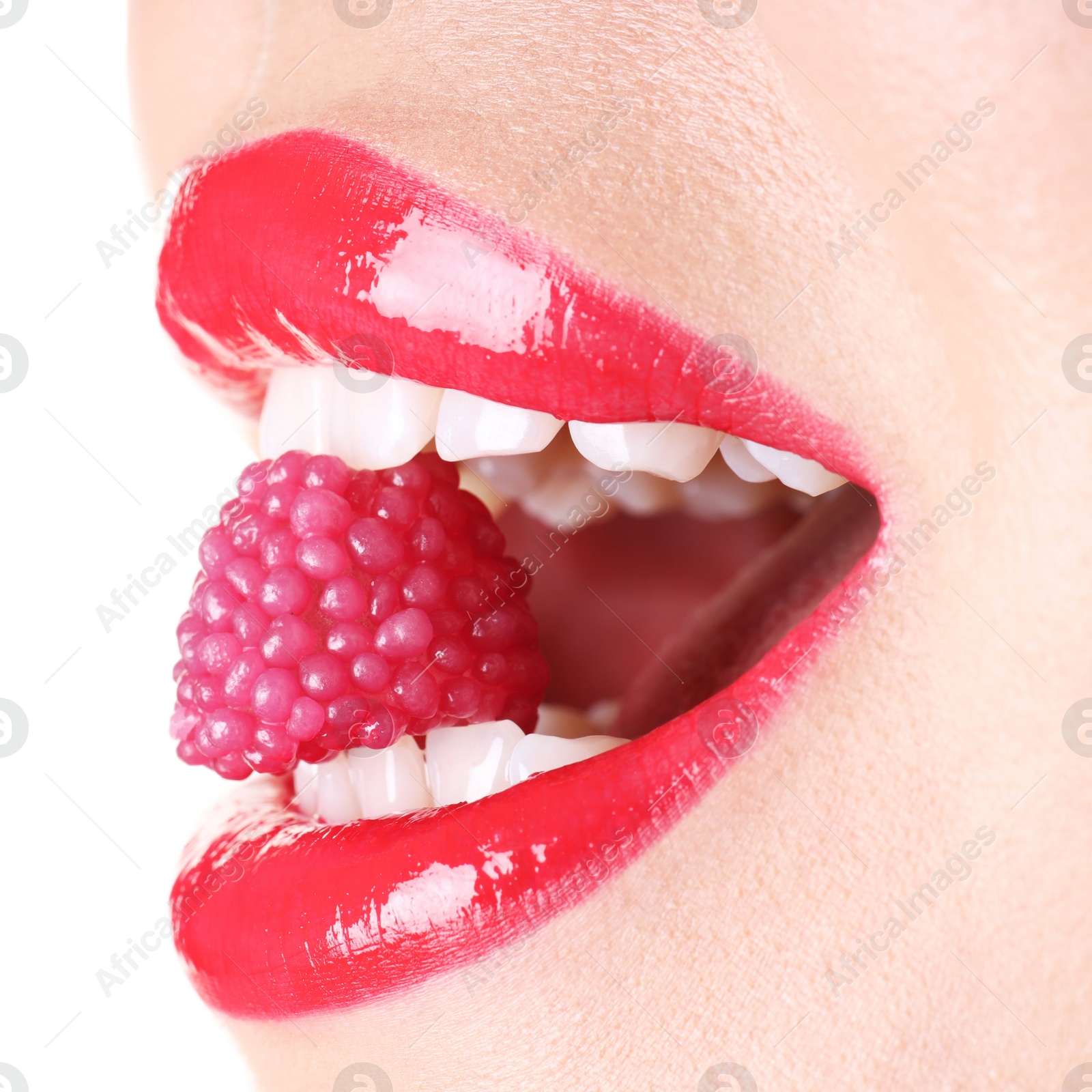 Photo of Woman with beautiful red lipstick on her lips and raspberry candy against white background, closeup