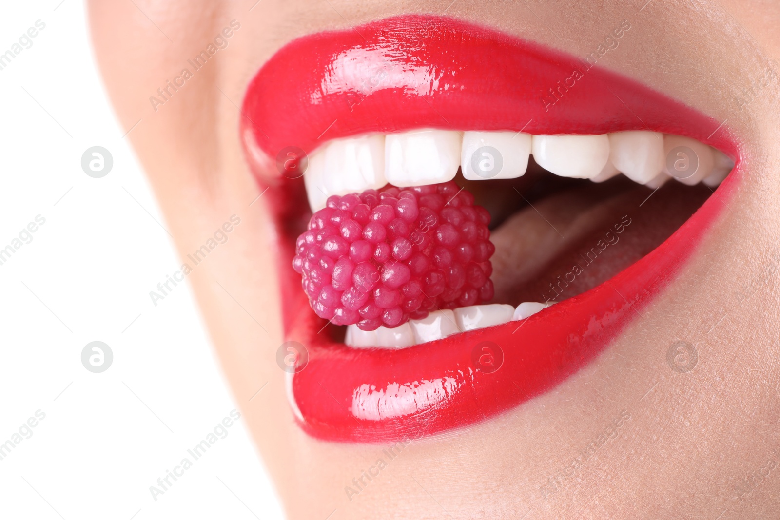 Photo of Woman with beautiful red lipstick on her lips and raspberry candy against white background, closeup