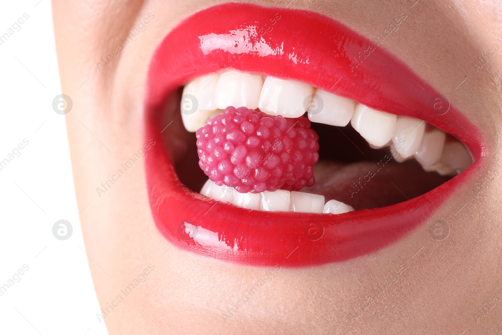 Photo of Woman with beautiful red lipstick on her lips and raspberry candy against white background, closeup
