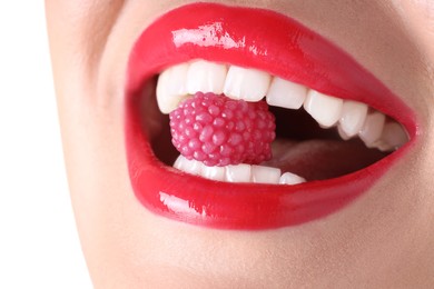 Photo of Woman with beautiful red lipstick on her lips and raspberry candy against white background, closeup