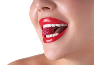Photo of Woman with beautiful red lipstick on her lips and raspberry candy against white background, closeup