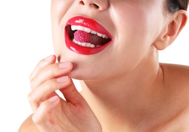 Photo of Woman with beautiful red lipstick on her lips and raspberry candy against white background, closeup