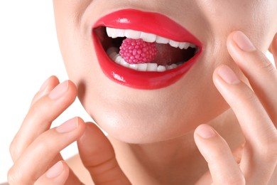 Photo of Woman with beautiful red lipstick on her lips and raspberry candy against white background, closeup