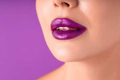 Photo of Woman with bright lipstick on purple background, macro view