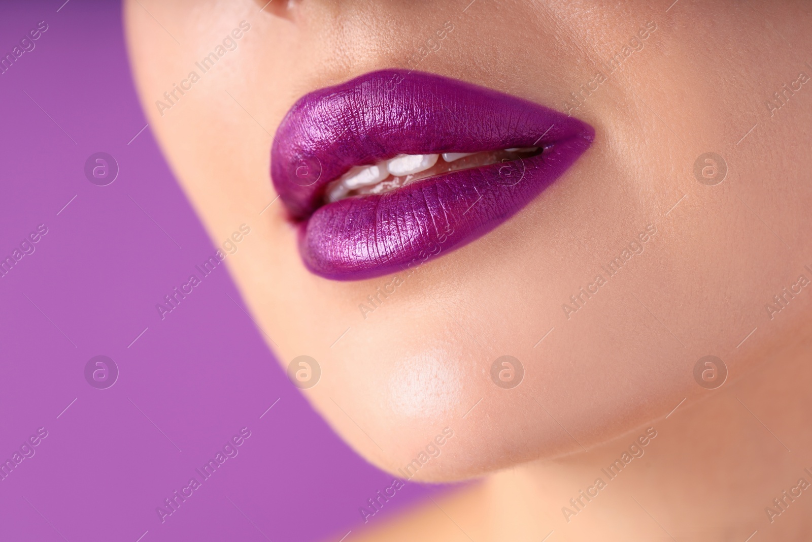 Photo of Woman with bright lipstick on purple background, macro view