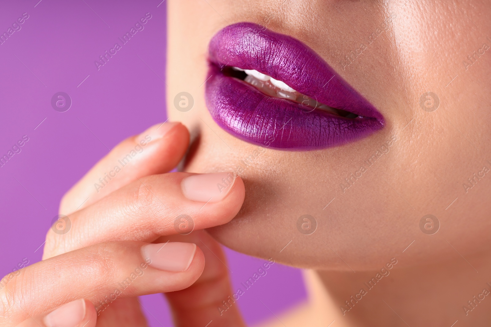Photo of Woman with bright lipstick on purple background, macro view