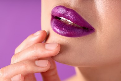 Photo of Woman with bright lipstick on purple background, macro view
