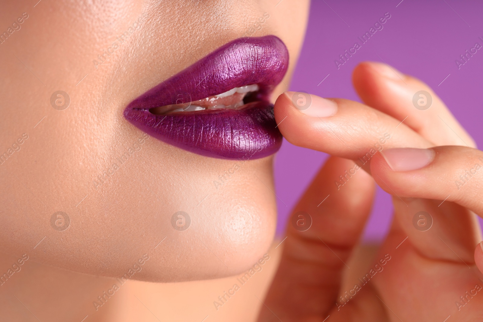 Photo of Woman with bright lipstick on purple background, macro view
