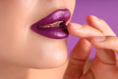 Photo of Woman with bright lipstick on purple background, macro view