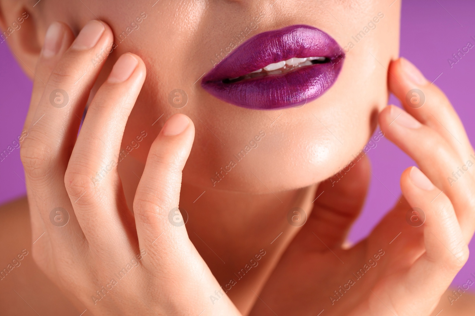 Photo of Woman with bright lipstick on purple background, macro view