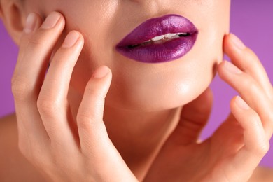 Photo of Woman with bright lipstick on purple background, macro view