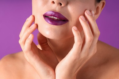Photo of Woman with bright lipstick on purple background, macro view
