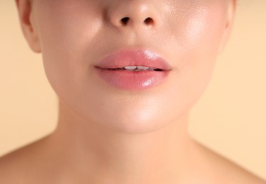 Photo of Woman with beautiful lips on beige background, macro view