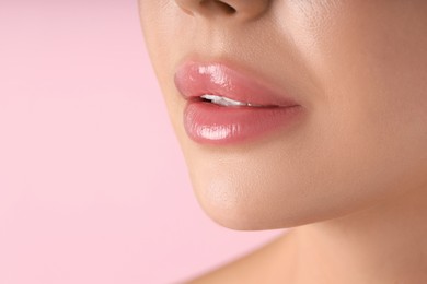 Photo of Woman with beautiful lips on pink background, macro view. Space for text