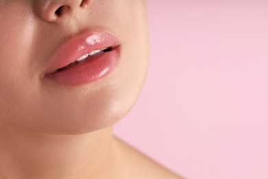 Photo of Woman with beautiful lips on pink background, macro view. Space for text
