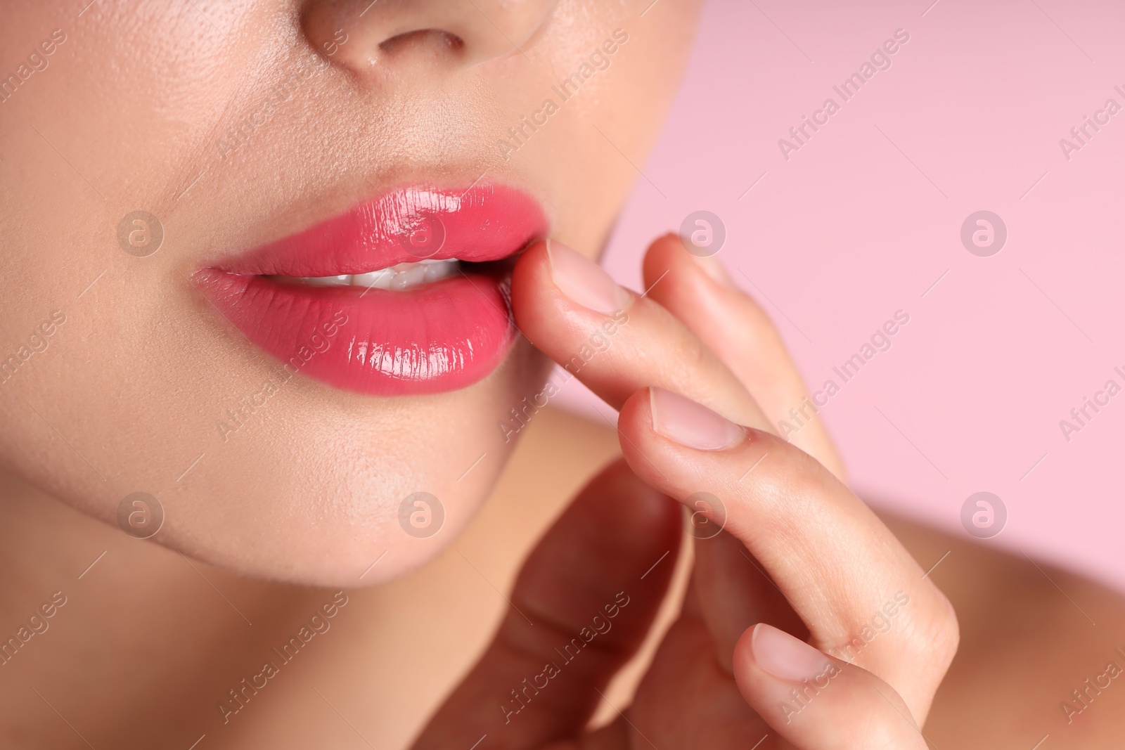 Photo of Woman with beautiful lipstick on her lips against pink background, macro view