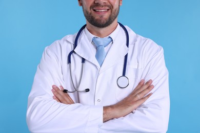 Photo of Pediatrician with stethoscope on light blue background, closeup
