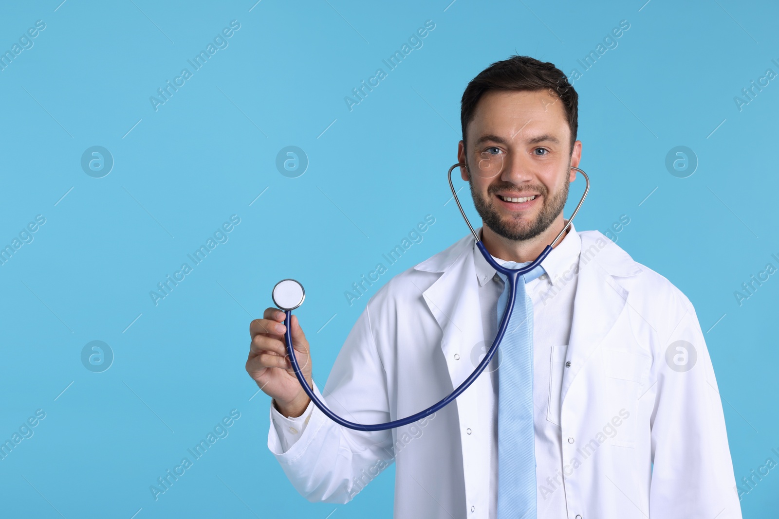 Photo of Pediatrician with stethoscope on light blue background. Space for text
