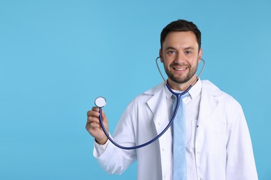 Photo of Pediatrician with stethoscope on light blue background. Space for text