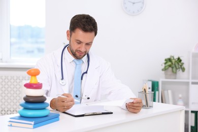Photo of Professional pediatrician working at desk in hospital