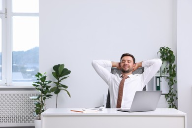 Photo of Man sitting at workplace in office with air conditioning