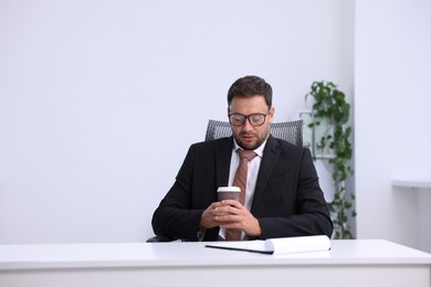 Photo of Air conditioning. Man with cup of hot drink suffering from cold temperature at workplace in office