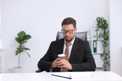 Photo of Air conditioning. Man with cup of hot drink suffering from cold temperature at workplace in office
