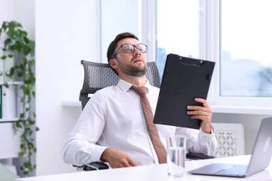 Photo of Air conditioning. Man suffering from heat at workplace in office