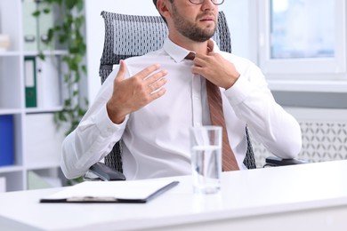 Photo of Air conditioning. Man suffering from heat at workplace in office, closeup