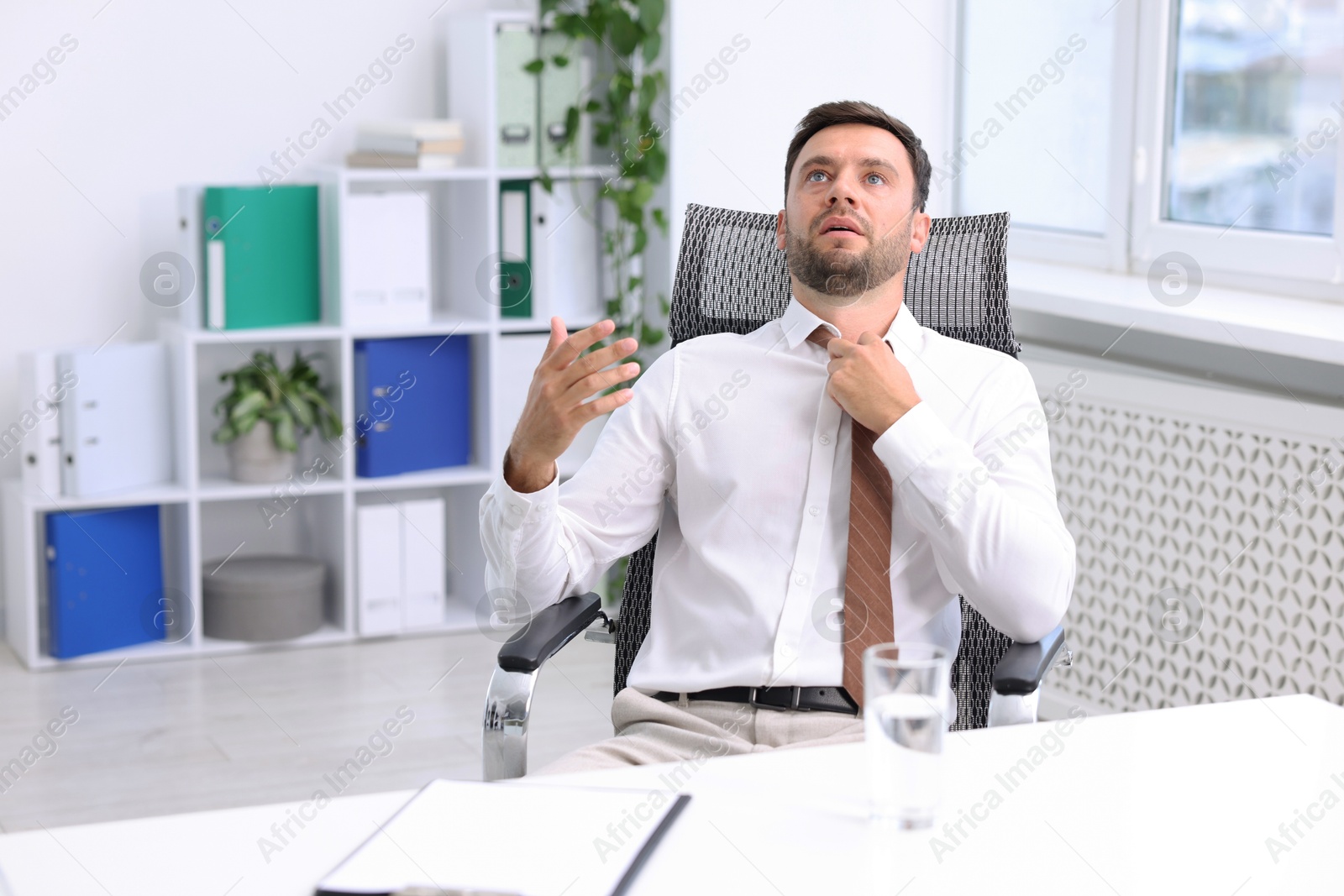 Photo of Air conditioning. Man suffering from heat at workplace in office