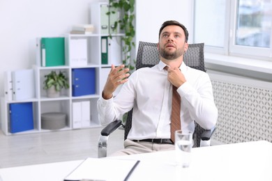 Photo of Air conditioning. Man suffering from heat at workplace in office