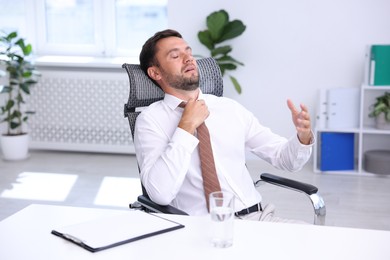 Photo of Air conditioning. Man suffering from heat at workplace in office