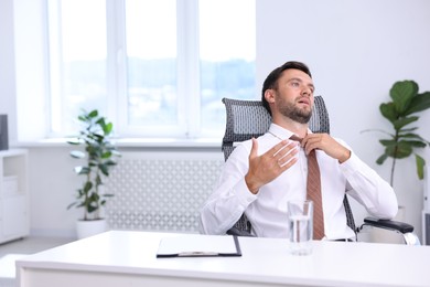 Photo of Air conditioning. Man suffering from heat at workplace in office