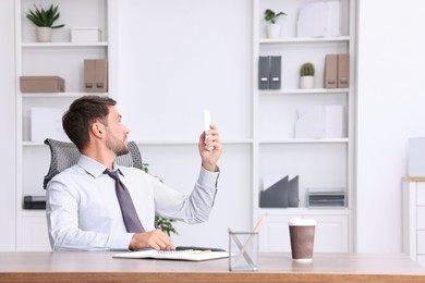Photo of Man using remote to control air conditioner in office