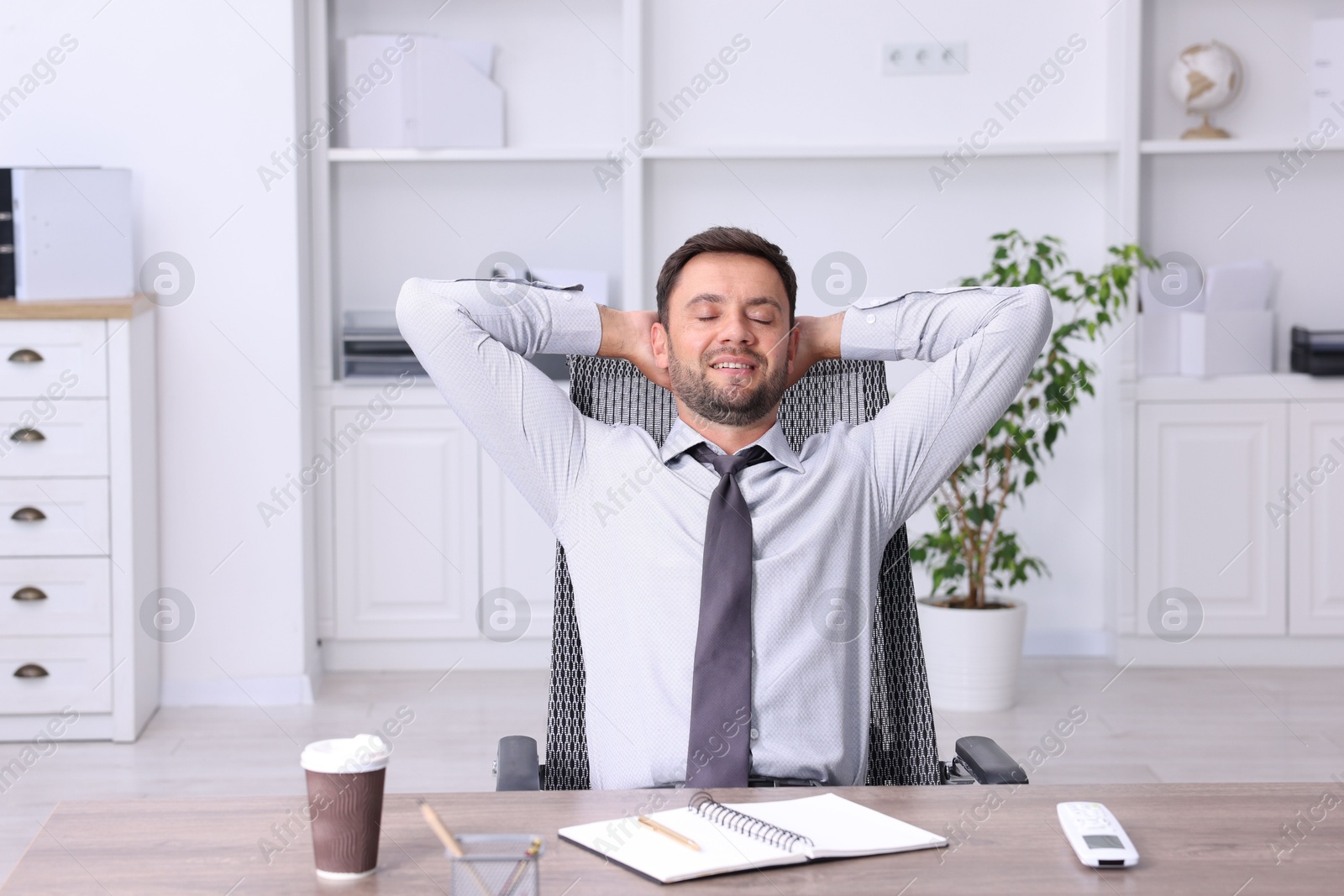 Photo of Man sitting at workplace in office with air conditioning