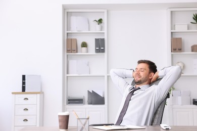 Photo of Man sitting at workplace in office with air conditioning