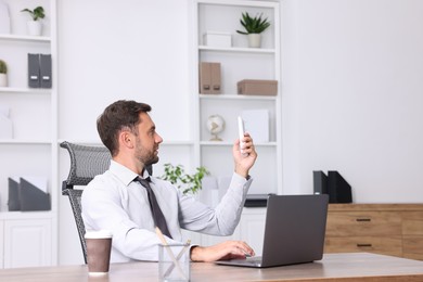 Photo of Man using remote to control air conditioner in office