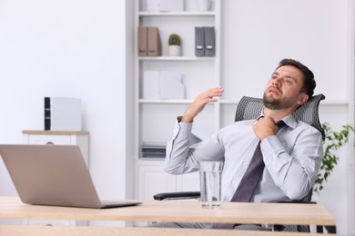 Photo of Air conditioning. Man suffering from heat at workplace in office