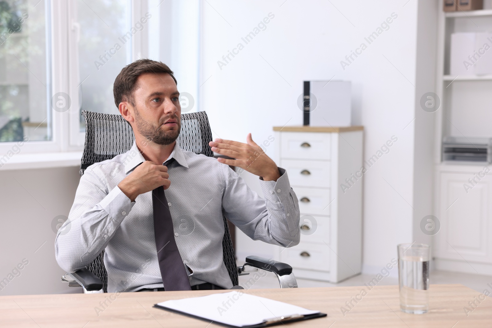 Photo of Air conditioning. Man suffering from heat at workplace in office