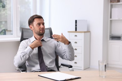 Photo of Air conditioning. Man suffering from heat at workplace in office
