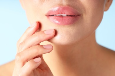 Photo of Woman with beautiful lips on light blue background, macro view