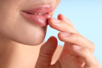 Photo of Woman with beautiful lips on light blue background, macro view