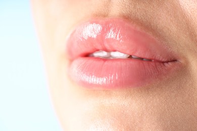 Photo of Woman with beautiful lips on light blue background, macro view