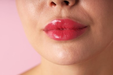 Photo of Woman with beautiful lipstick on her lips against pink background, macro view