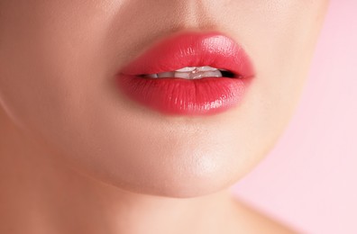 Photo of Woman with beautiful lipstick on her lips against pink background, macro view