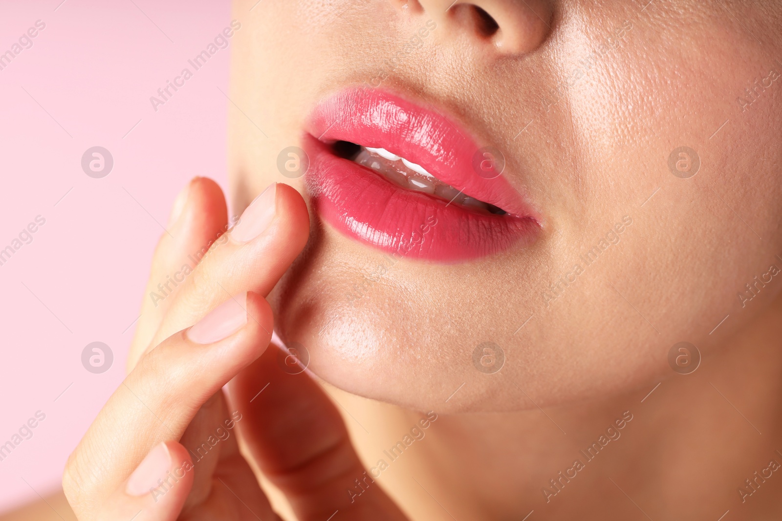 Photo of Woman with beautiful lipstick on her lips against pink background, macro view