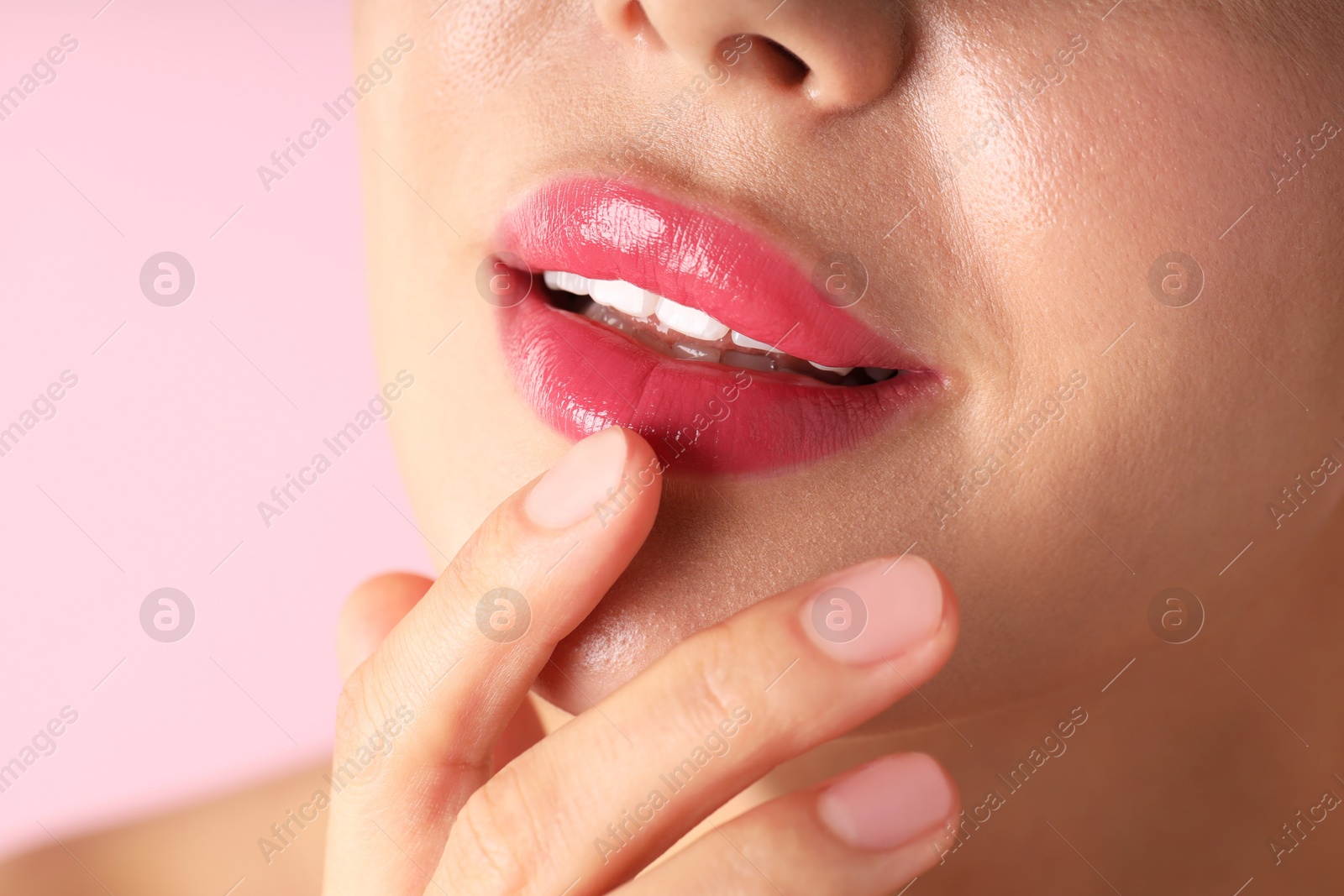Photo of Woman with beautiful lipstick on her lips against pink background, macro view